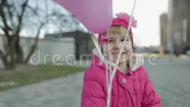 快乐可爱的孩子在街上拿着气球和氦。 生日聚会